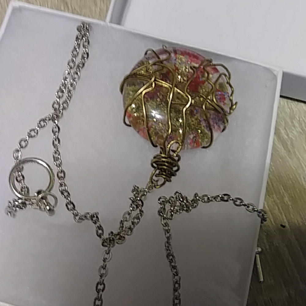 A large Gold Wire Wrapped Pendant on a silver chai